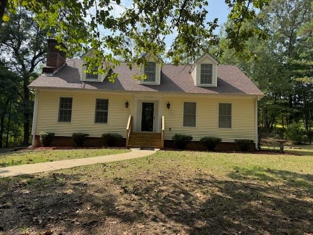 cape cod home with a front lawn