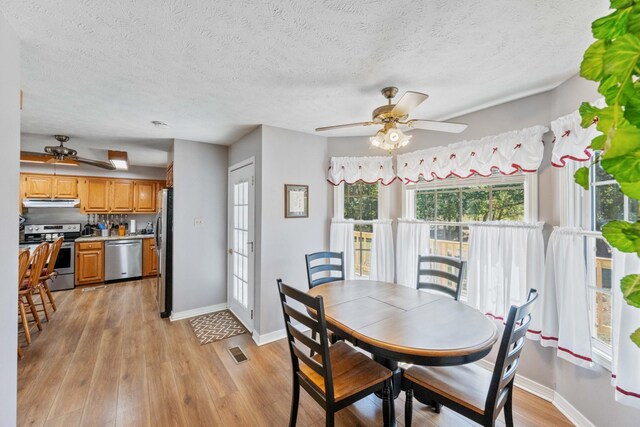 dining space with a textured ceiling, light hardwood / wood-style flooring, and ceiling fan