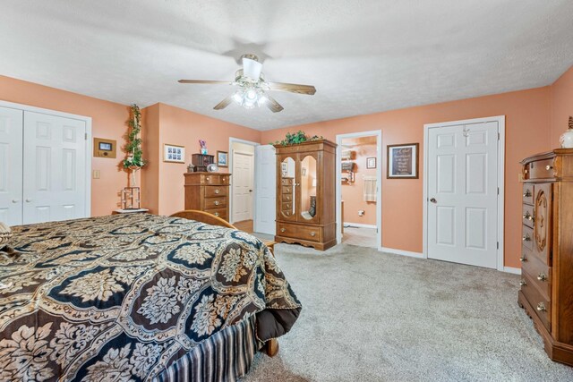 carpeted bedroom featuring ensuite bath, a textured ceiling, and ceiling fan