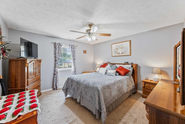 bedroom featuring light carpet, a textured ceiling, and ceiling fan