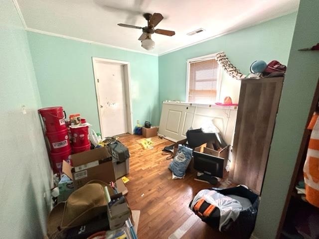 miscellaneous room featuring ceiling fan, crown molding, and wood-type flooring