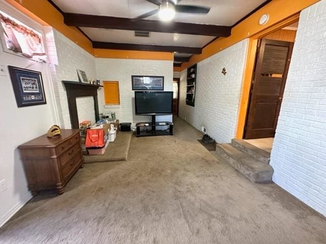 interior space with light carpet, brick wall, beam ceiling, and ceiling fan