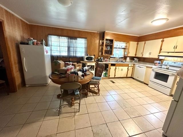 kitchen featuring crown molding, wood walls, light tile patterned floors, and white appliances