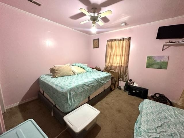 carpeted bedroom with ornamental molding and ceiling fan