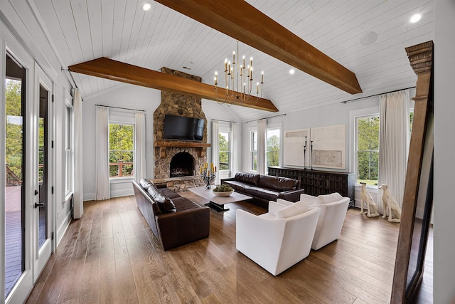 living room with lofted ceiling with beams, a wealth of natural light, and hardwood / wood-style flooring