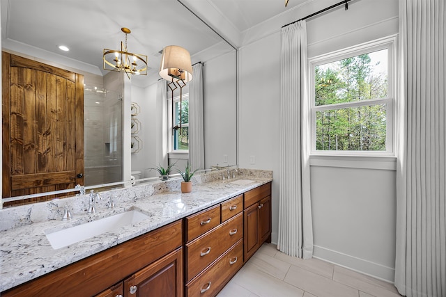 bathroom featuring a sink, tiled shower, a chandelier, and ornamental molding