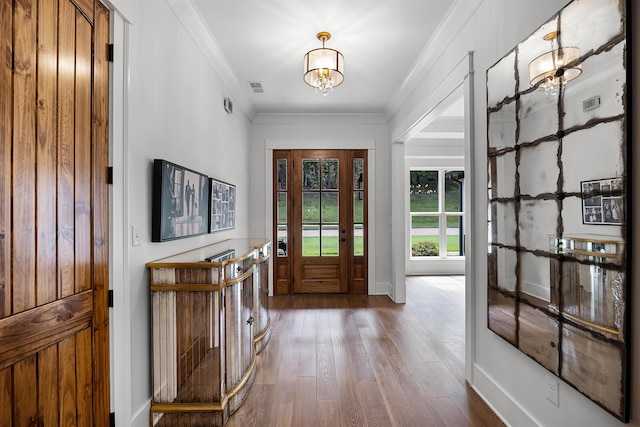 entryway featuring a notable chandelier, ornamental molding, and dark hardwood / wood-style floors