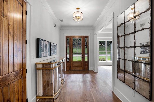 entrance foyer with visible vents, a notable chandelier, ornamental molding, baseboards, and dark wood-style flooring