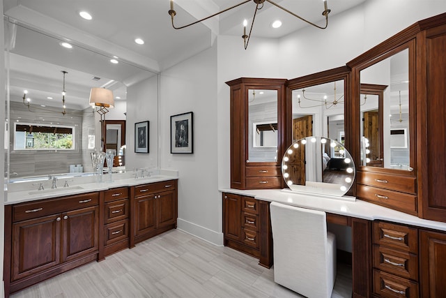 bathroom featuring a chandelier, recessed lighting, double vanity, and a sink