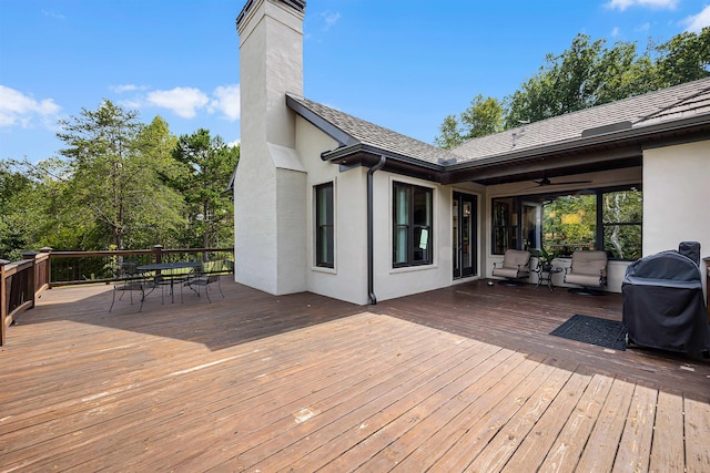 wooden terrace featuring area for grilling and outdoor dining space