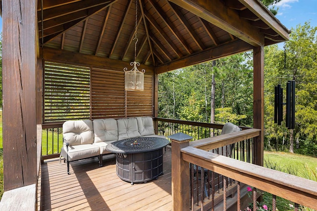 wooden terrace featuring an outdoor living space with a fire pit and a gazebo