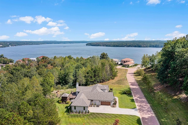 birds eye view of property with a view of trees and a water view