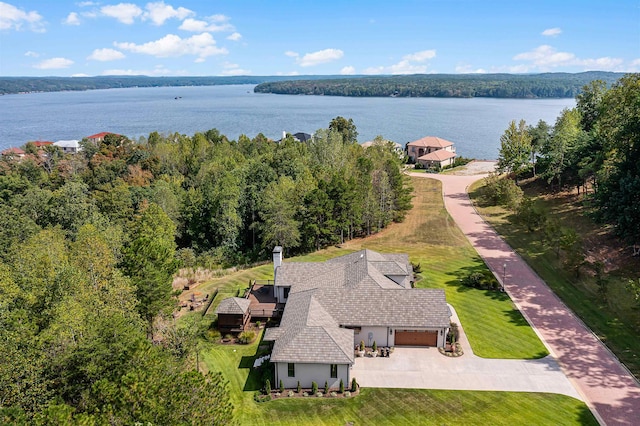 aerial view featuring a forest view and a water view