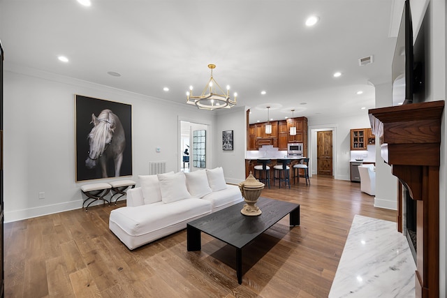 living area with recessed lighting, wood finished floors, and visible vents