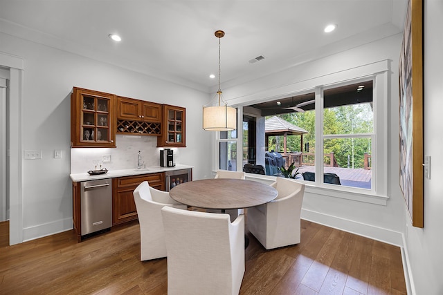 dining space featuring dark wood-style floors, visible vents, baseboards, recessed lighting, and indoor wet bar