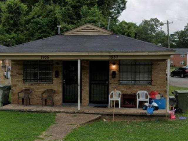 bungalow featuring brick siding