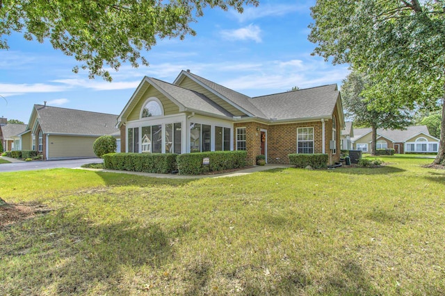 view of front of home with a sunroom and a front lawn