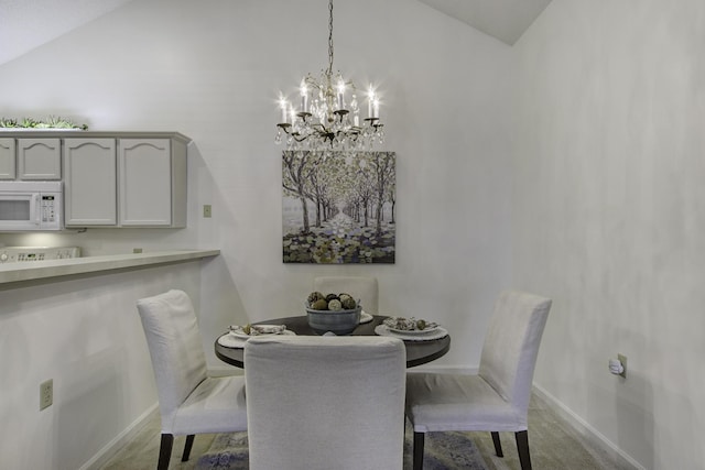 dining space featuring a notable chandelier, carpet flooring, lofted ceiling, and baseboards