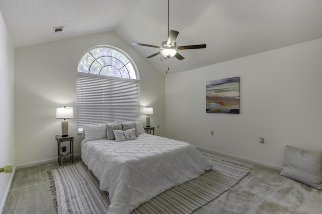 carpeted bedroom featuring baseboards, visible vents, ceiling fan, vaulted ceiling, and a textured ceiling