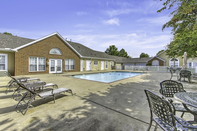 pool featuring a patio area, french doors, and fence