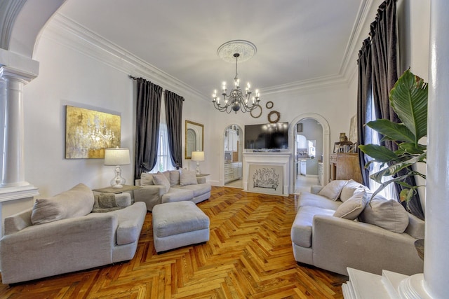 living room with parquet floors, ornamental molding, a chandelier, and decorative columns