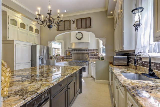 kitchen featuring decorative light fixtures, dark brown cabinets, backsplash, appliances with stainless steel finishes, and sink