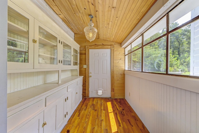 unfurnished sunroom featuring wooden ceiling and lofted ceiling