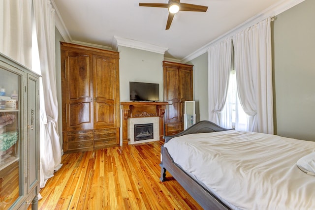 bedroom with light wood-type flooring, ceiling fan, and ornamental molding