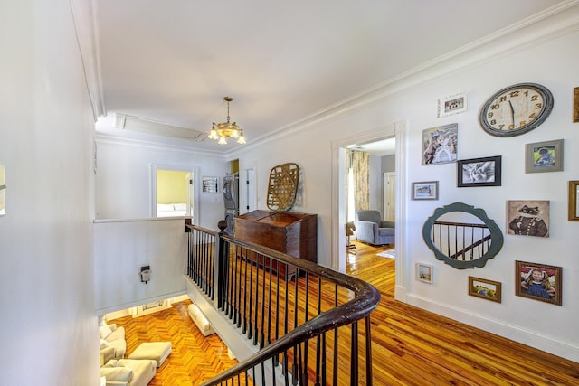 hallway featuring light wood-type flooring, an inviting chandelier, and ornamental molding