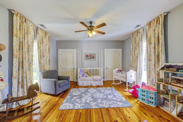 interior space featuring multiple windows, ceiling fan, and light hardwood / wood-style flooring