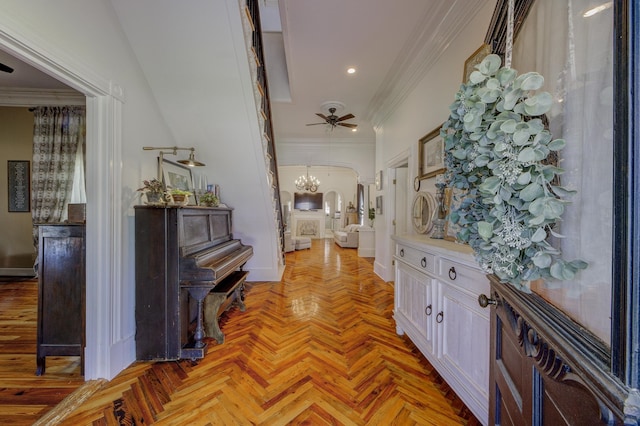 hallway with crown molding, light parquet floors, and an inviting chandelier