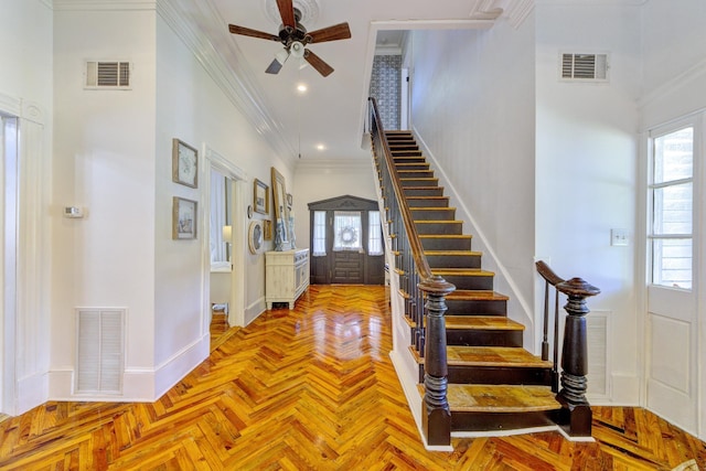 interior space with ceiling fan, plenty of natural light, light parquet floors, and crown molding