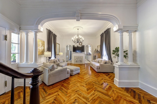 living room featuring decorative columns, a chandelier, and crown molding