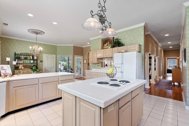 kitchen featuring white appliances, light brown cabinetry, crown molding, a center island, and light wood-type flooring