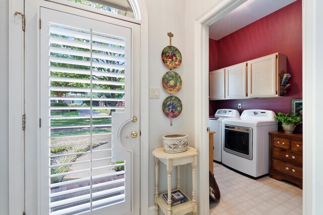 laundry room featuring washing machine and clothes dryer and cabinets