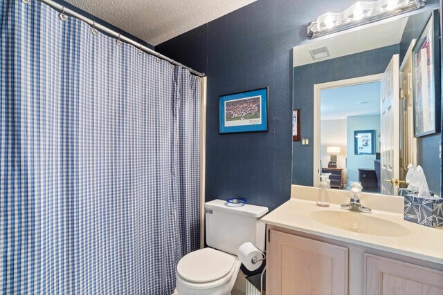 bathroom featuring a shower with shower curtain, toilet, a textured ceiling, and vanity