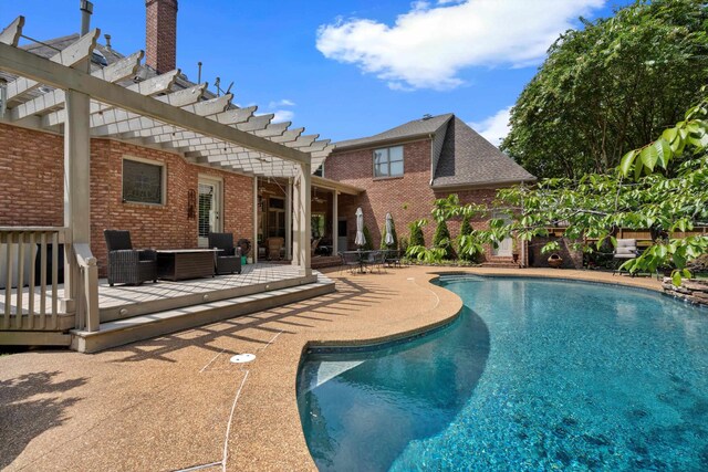 view of swimming pool featuring a pergola, a deck, and a patio