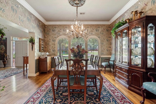 dining room featuring hardwood / wood-style floors, a chandelier, and ornamental molding