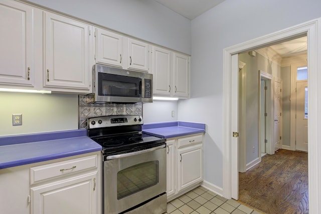 kitchen featuring stainless steel appliances, light wood-type flooring, and white cabinetry