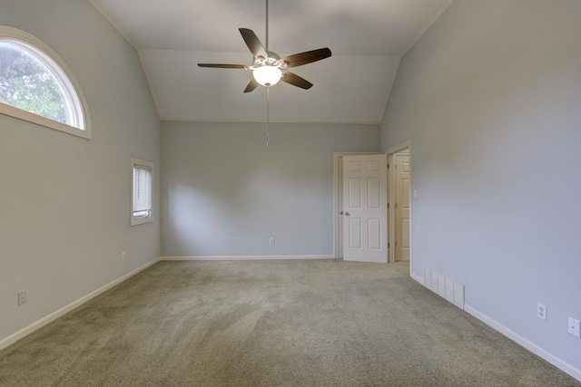 carpeted empty room with high vaulted ceiling and ceiling fan