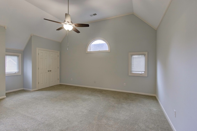 carpeted empty room featuring high vaulted ceiling and ceiling fan