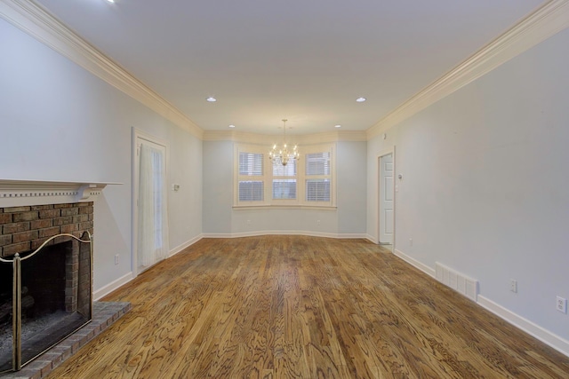 unfurnished living room featuring crown molding, a brick fireplace, hardwood / wood-style floors, and a chandelier