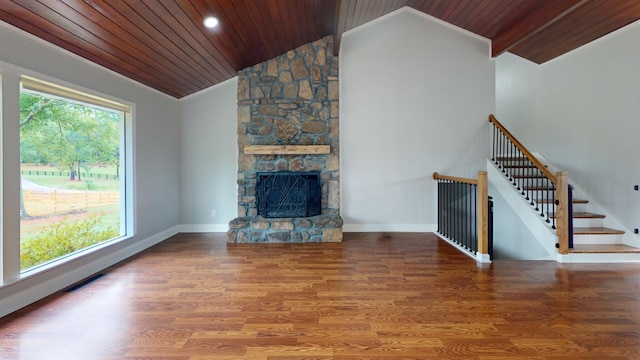 unfurnished living room featuring wooden ceiling, vaulted ceiling, hardwood / wood-style floors, and a stone fireplace