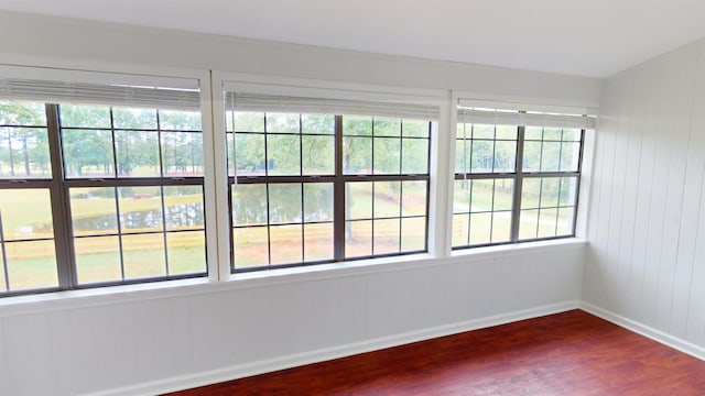 spare room with hardwood / wood-style flooring and wood walls