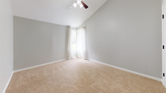 spare room with lofted ceiling, ceiling fan, and light carpet