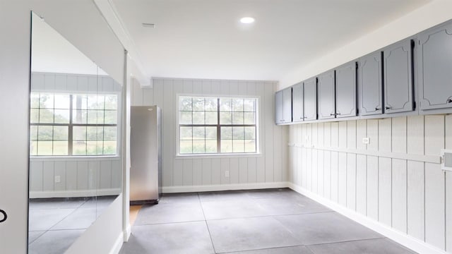 interior space featuring tile patterned flooring, plenty of natural light, and ornamental molding