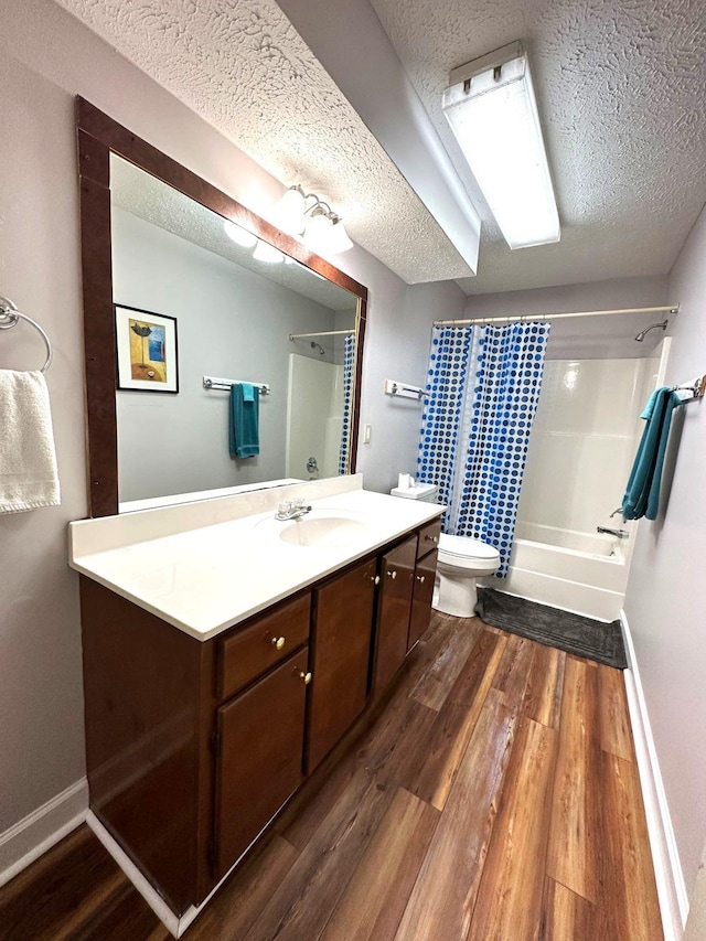 full bathroom with vanity, toilet, hardwood / wood-style flooring, and a textured ceiling