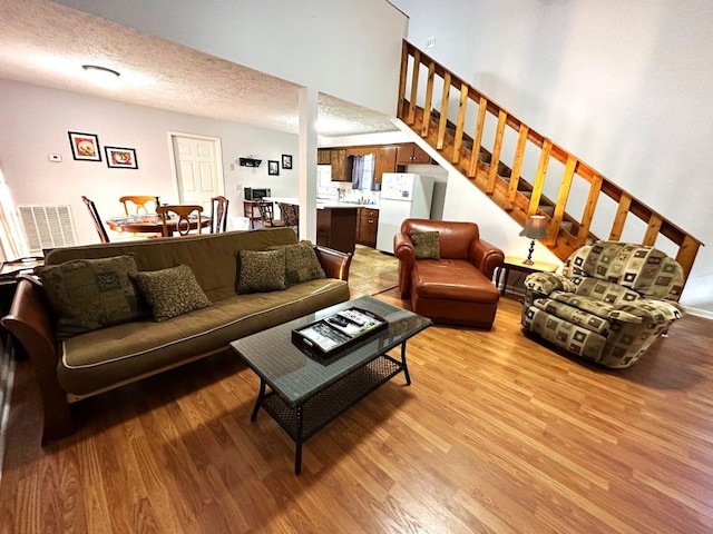 living room featuring a textured ceiling and light hardwood / wood-style flooring