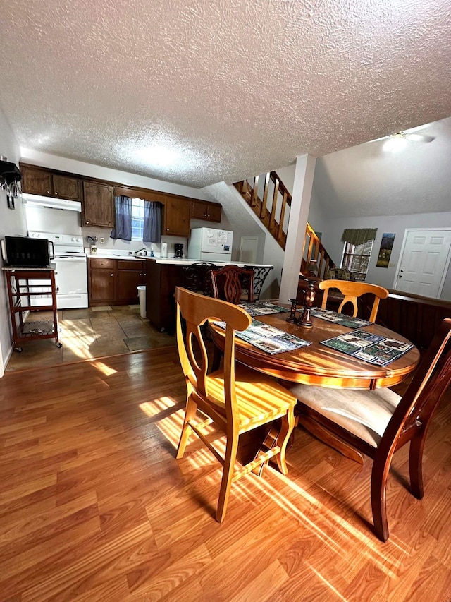 dining space featuring sink, a textured ceiling, and light hardwood / wood-style flooring