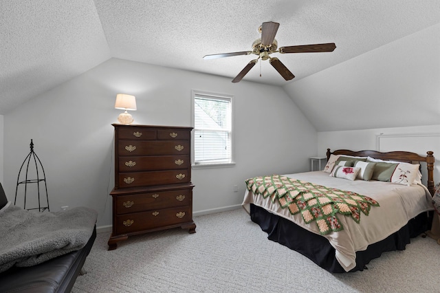 bedroom with lofted ceiling, ceiling fan, light colored carpet, and a textured ceiling